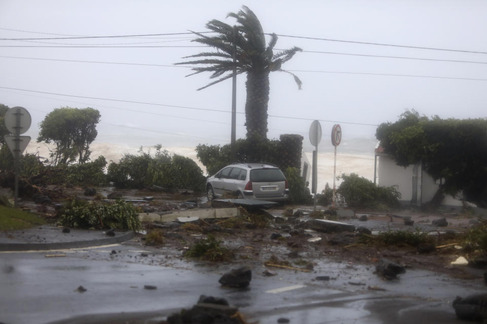 Debris blocks a road in the seafront village of Feteira, outside Horta, in the Portuguese island of Faial, Wednesday, Oct. 2, 2019. Hurricane Lorenzo is lashing the mid-Atlantic Azores Islands with heavy rain, powerful winds and high waves. The Category 2 hurricane passed the Portuguese island chain Wednesday. (AP Photo/Joao Henriques)