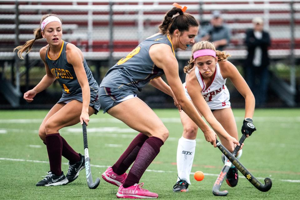 Milford sophomores Bailey Masten (4) keeps her eyes on the ball as teammate and sophomore Hannah Zimmerman (9) battles for the ball against Smyrna junior Dru Moffett (11) during the field hockey game at Smyrna, Tuesday, Oct. 25, 2022. Smyrna won 3-0.