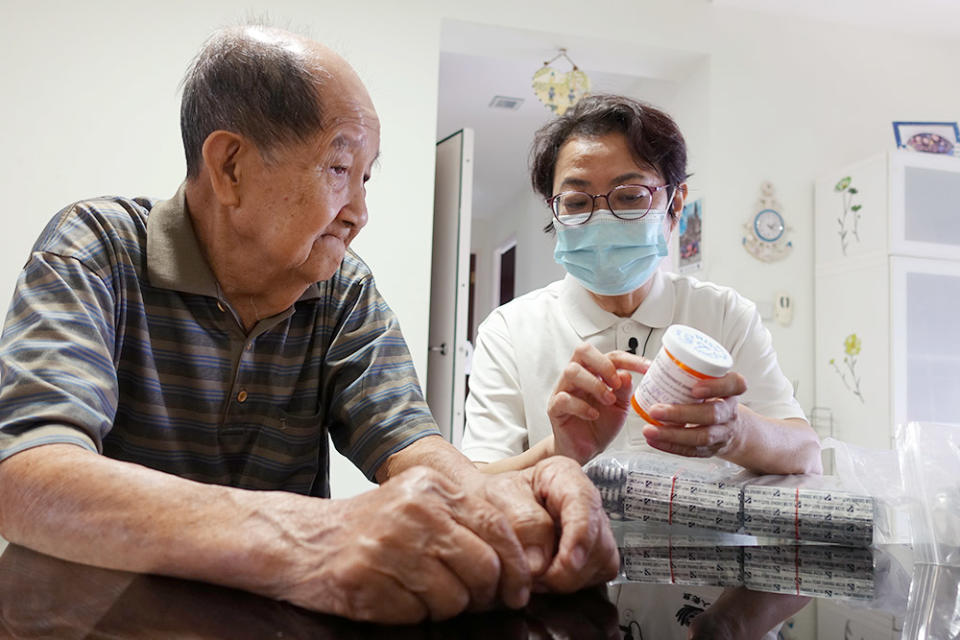 每次到醫院複診，胡爺爺（左）會領回一大袋、好幾個月份的藥，護士許繡香（右）上門時會再解釋每一種藥的功用。