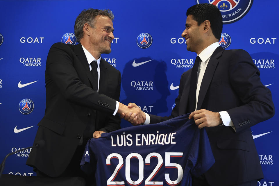 Luis Enrique (izquierda), nuevo técnico del Paris-Saint-Germain, saluda al presidente Nasser Al-Khelaifi durante una rueda de prensa, el miércoles 5 de julio de 2023, en Poissy, Francia. (AP Foto/Aurelien Morissard)