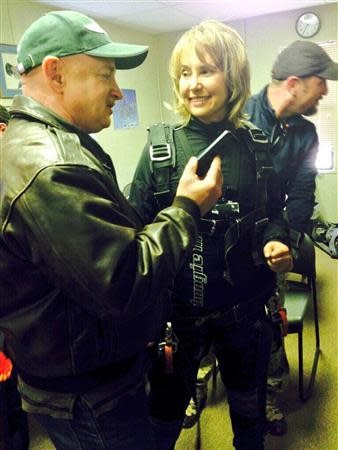 Former U.S. Congresswoman Gabrielle Giffords (C) is pictured with her husband, retired astronaut and U.S. Navy captain Mark Kelly (L) prior to skydiving in this January 8, 2014 Twitter picture from her handle @GabbyGiffords. REUTERS/Gabrielle Giffords/Handout via Reuters