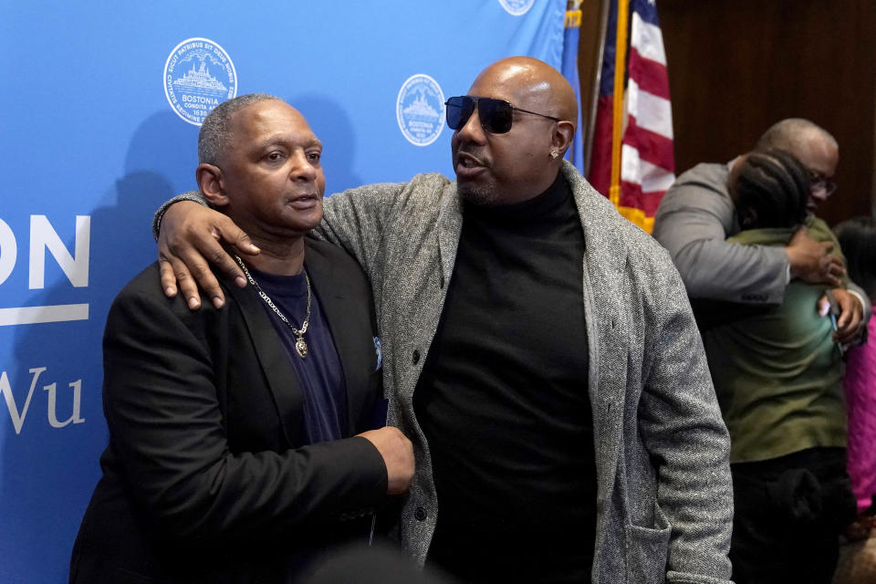 Alan Swanson, left, is embraced by Joseph Bennett, nephew of Willie Bennett, center, following a news conference Wednesday, Dec. 20, 2023, in Boston. Boston Mayor Michelle Wu issued a formal apology Wednesday to Swanson and Willie Bennett for their wrongful arrests following the 1989 death of Carol Stuart, whose husband, Charles Stuart, had orchestrated her murder. Joseph Bennett accepted the formal apology on behalf of Willie Bennett who was not present at the news conference Wednesday. (AP Photo/Steven Senne)