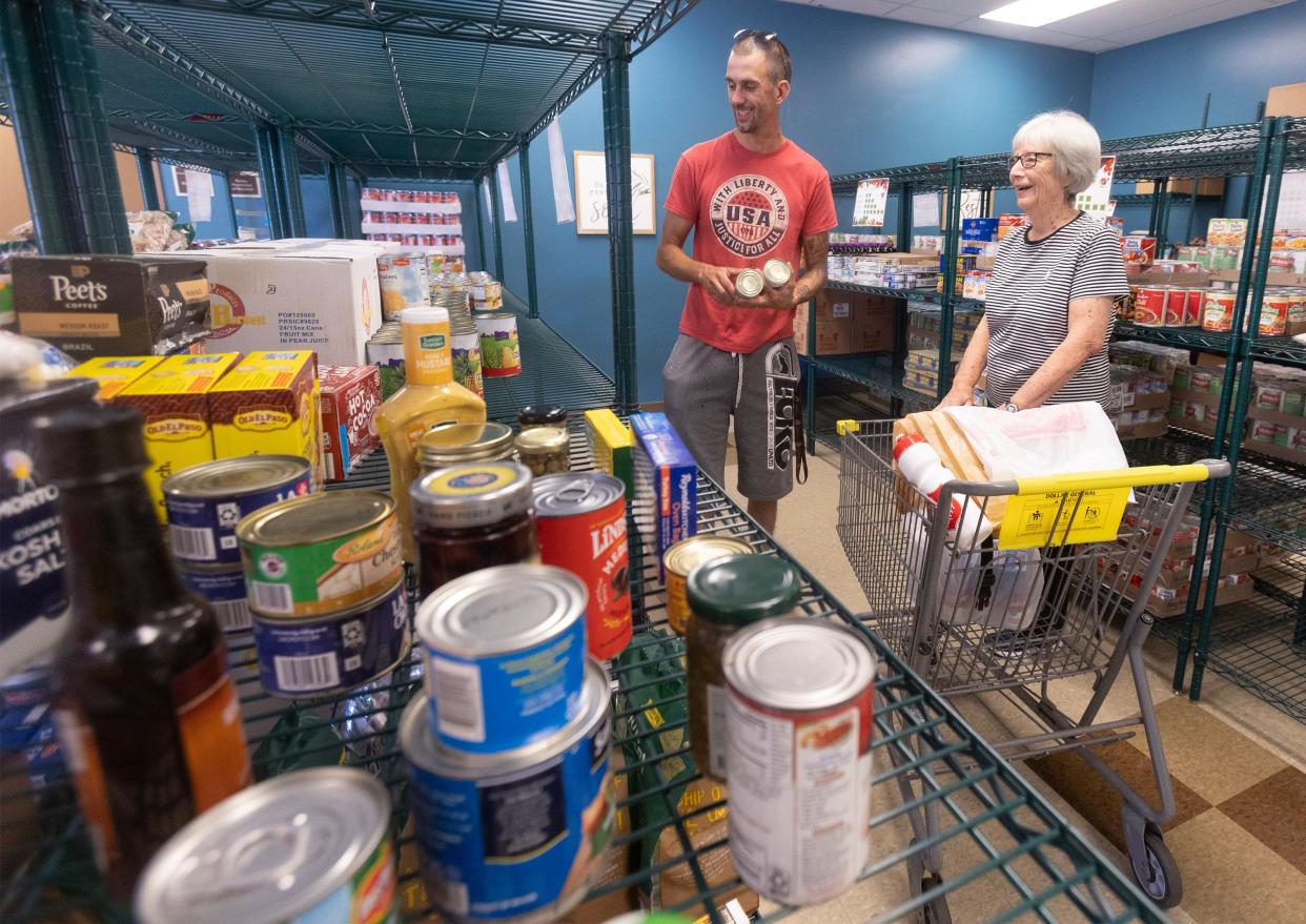 Judy Busby, a Salvation Army volunteer, shops with client Jason Harvey at the Massillon Salvation Army's choice food pantry.