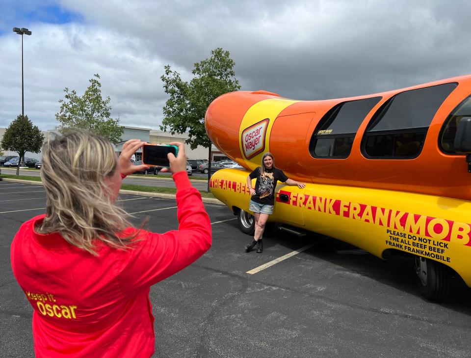 Anna Murphy-Pociask, on the marketing team at Oscar Mayer, takes a photo of someone posing with the iconic Frankmobile. The unique vehicle will be in downtown Canton on Friday.