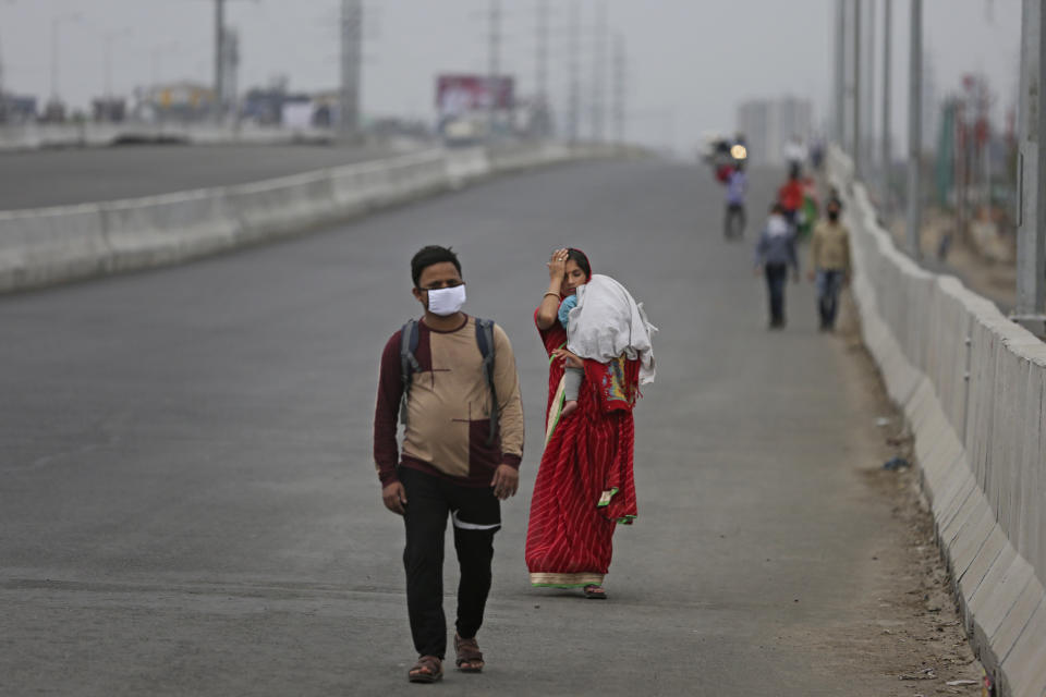 In this Thursday, March 26, 2020, file photo, an Indian couple carrying an infant walk along an expressway hoping to reach their home, hundreds of miles away, as the city comes under lockdown in Ghaziabad, on the outskirts of New Delhi, India. Over the past week, India’s migrant workers - the mainstay of the country’s labor force - spilled out of big cities that have been shuttered due to the coronavirus and returned to their villages, sparking fears that the virus could spread to the countryside. It was an exodus unlike anything seen in India since the 1947 Partition, when British colothe subcontinent, with the 21-day lockdown leaving millions of migrants with no choice but to return to their home villages. (AP Photo/Altaf Qadri, File)