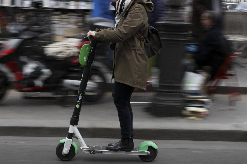 Une femme utilise une trottinette électrique Lime à Paris, le 3 mars 2019.