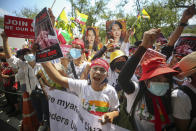 Myanmar nationals living in Thailand hold pictures of deposed Myanmar leader Aung San Suu Kyi as they protest against the military coup in front of the United Nations building i in Bangkok, Thailand, Sunday, March 7, 2021. (AP Photo/Nava Sangthong)