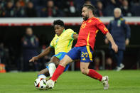 Brazil's Endrick, left and Spain's Dani Carvajal challenge for the ball during a friendly soccer match between Spain and Brazil at the Santiago Bernabeu stadium in Madrid, Spain, Tuesday, March 26, 2024. (AP Photo/Jose Breton)