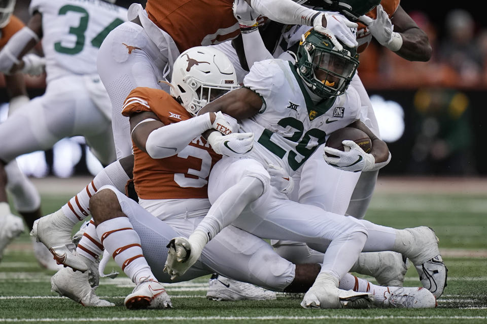 Baylor running back Richard Reese (29) is stopped by Texas linebacker Diamonte Tucker-Dorsey (3) during the second half of an NCAA college football game in Austin, Texas, Friday, Nov. 25, 2022. (AP Photo/Eric Gay)