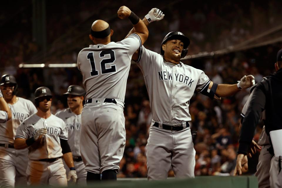 New York Yankees designated hitter Giancarlo Stanton (right) celebrates with second baseman Rougned Odor (left, 12) after hitting a grand slam against the Boston Red Sox during the eighth inning at Fenway Park on Saturday.