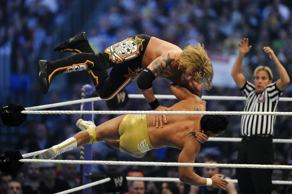 WWE Superstars Edge dives off the ropes to take down Alberto Del Rio in front of a sold-out, record crowd of 71,617 during WrestleMania XXVII at the Georgia Dome in Atlanta, Georgia on Sunday, April 3, 2011. (Paul Abell/AP Images for WWE)