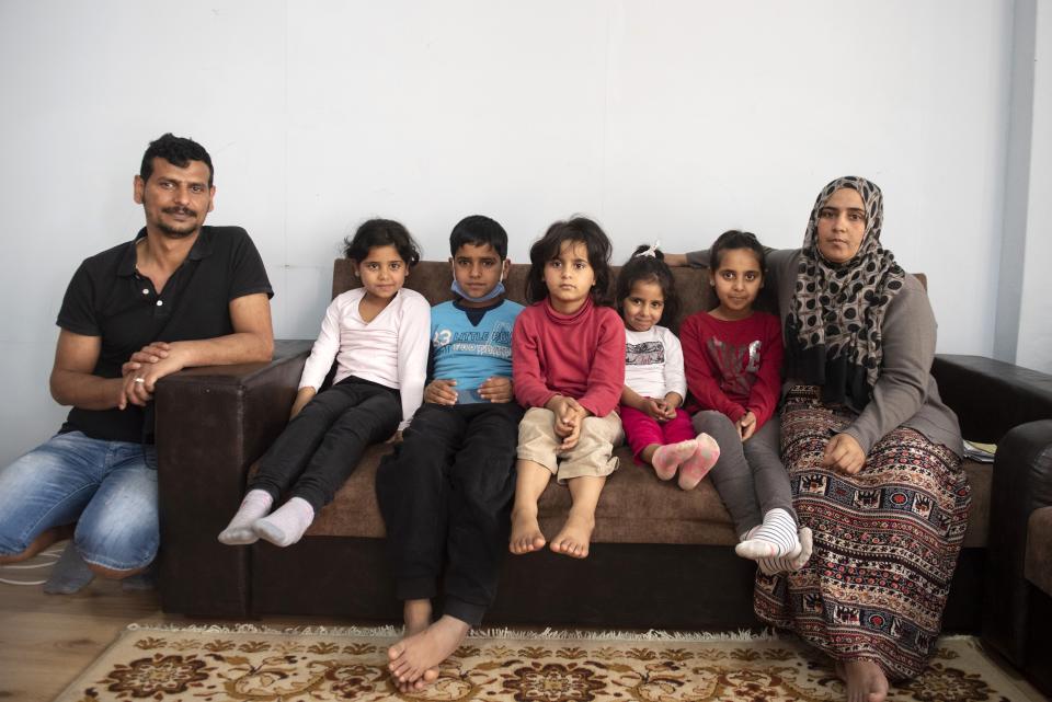 Abdul Salam Al Khawien, 37, left, and his wife Kariman, 32, right, pose with their children for a family photo, at their apartment in the northern city of Thessaloniki, Greece, Saturday, May 1, 2021. Sundered in the deadly chaos of an air raid, a Syrian family of seven has been reunited, against the odds, three years later at a refugee shelter in Greece's second city of Thessaloniki. (AP Photo/Giannis Papanikos)
