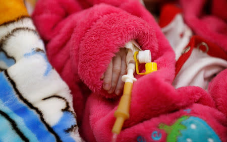 The hand of a malnourished boy is pictured as he lies on a bed at a malnutrition treatment center in Sanaa, Yemen November 21, 2017. REUTERS/Khaled Abdullah