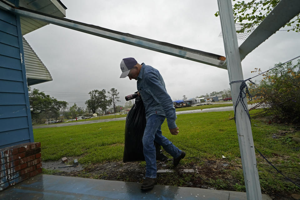 Jim Fontenot carries possessions into his brother's home, to which his family temporarily relocated to ride out Hurricane Delta which is expected to make landfall later in the day, in Lake Charles, La., Friday, Oct. 9, 2020. (AP Photo/Gerald Herbert)