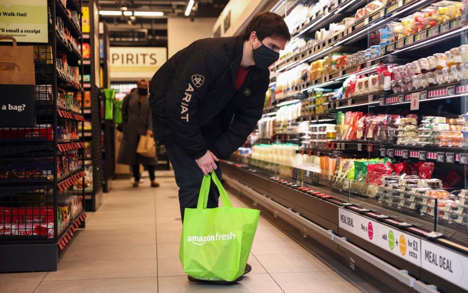 A customer looks at products in the UK’s first Amazon Fresh supermarket, in London - HENRY NICHOLLS /REUTERS 