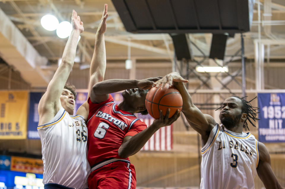 La Salle's Anwar Gill, right, blocks the shot by Dayton's Enoch Cheeks, center, during the first half of an NCAA college basketball game Tuesday, Jan. 23, 2024, in Philadelphia. (AP Photo/Chris Szagola)