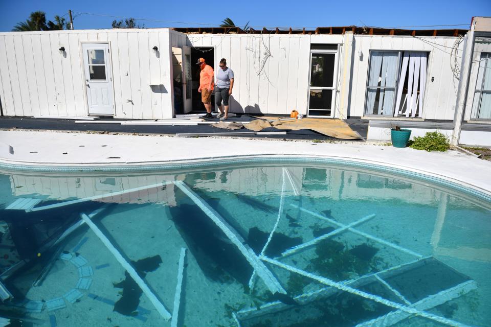Andrew Tartal and his fiance, Shana Queen, look over the house Tartal's mother rents in Port Charlotte Florida on Friday, Sept. 30, 2022. The home on Gardner Dr. lost most of the roof and pool cage during Hurricane Ian.