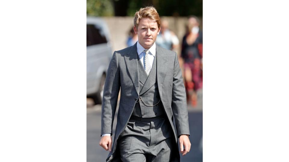 Hugh Grosvenor, Prince George's godfather, in a grey three-piece suit in the sunshine