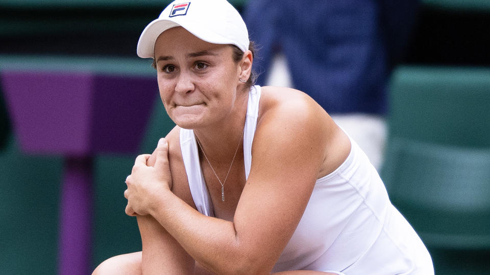 Ash Barty kneels down on the court during the 2021 Wimbledon final.