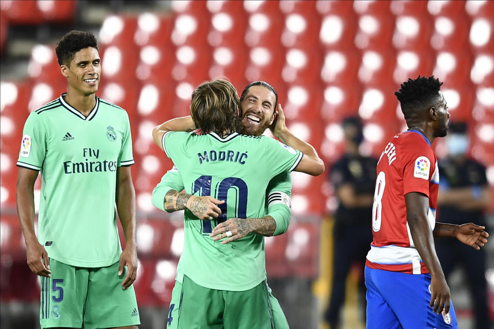 Sergio Ramos, del Real Madrid, celebra el triunfo de su equipo con su compañero Luka Modric al concluir el encuentro ante el Granada, el lunes 13 de julio de 2020, en Granada, España. (AP Foto/José Bretón)