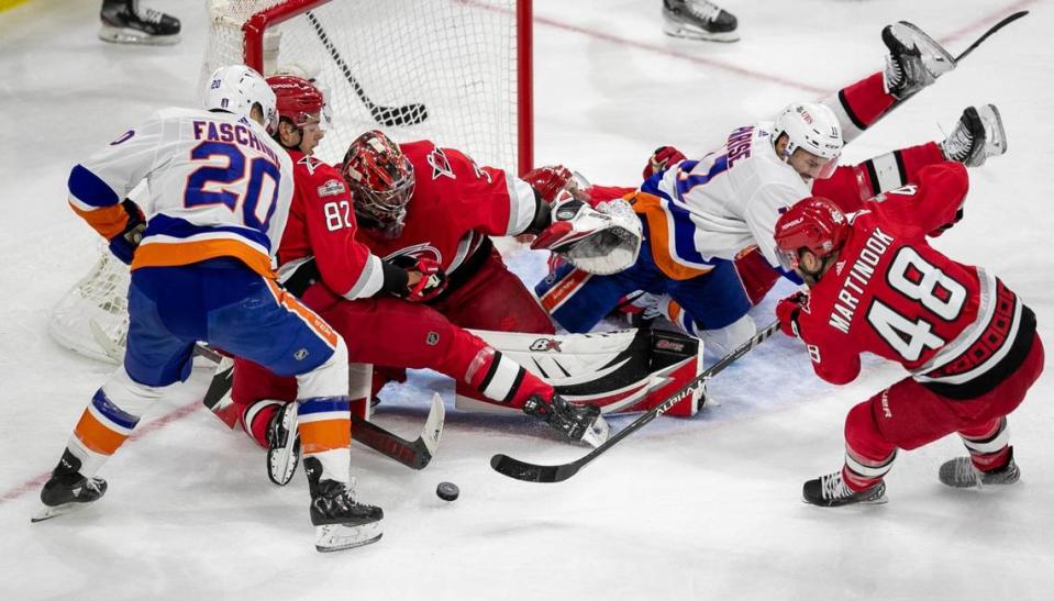 The Carolina Hurricanes Jesperi Kotkaniemi (82) and Jordan Martinook (48) work to clear the puck after a stop by goalie Antii Raanta (32) in the second period against the New York Islanders during Game 5 of their Stanley Cup series on Tuesday, April 25, 2023 at PNC Arena in Raleigh, N.C.