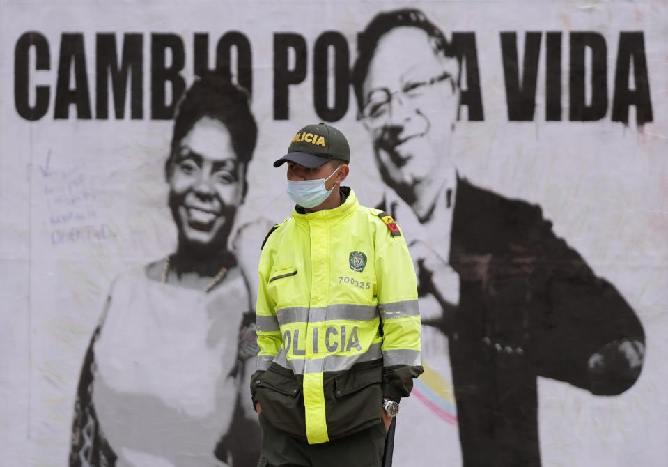 Un oficial de policía hace guardia cerca de un cartel de campaña del candidato presidencial Gustavo Petro y su compañera de fórmula Francia Márquez, con la coalición Pacto Histórico, antes de las elecciones del fin de semana en Bogotá, Colombia, el miércoles 25 de mayo de 2022. Los colombianos acuden a las urnas el mayo 29 para elegir un nuevo presidente. (AP Foto/Fernando Vergara)