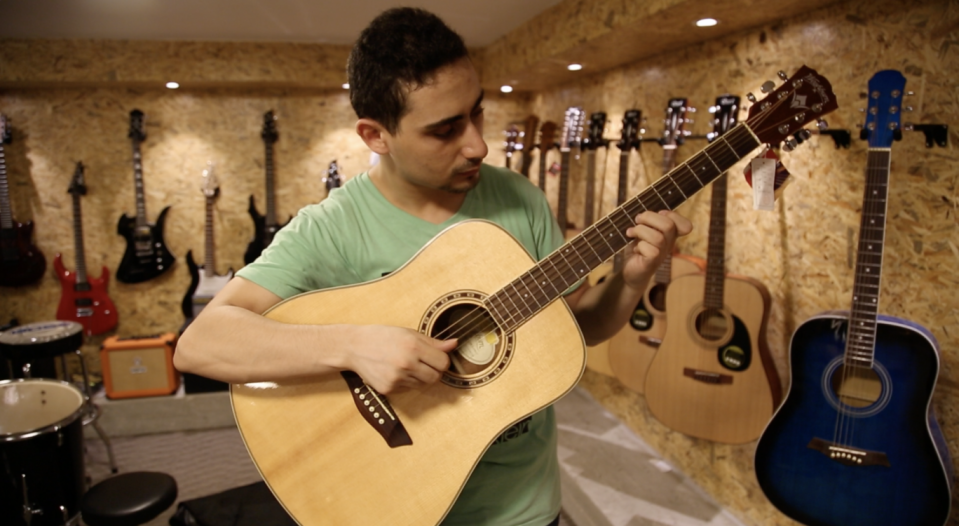 Raji Jaru, the owner of Gaza’s first music shop, plays the guitar (Photo: Bel Trew)