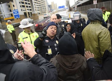 A police officer argues with a member of the Black Lives Matter protesters as they shut down the main road to the Minneapolis St. Paul Airport following a protest at the Mall of America in Bloomington, Minnesota December 23, 2015. REUTERS/Craig Lassig