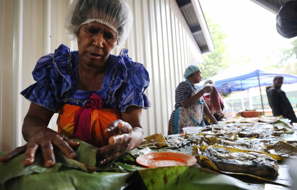 A vendor wraps food in a banana leaf at the Port Vila Central Market on November 30, 2019 in Port Vila, Vanuatu.