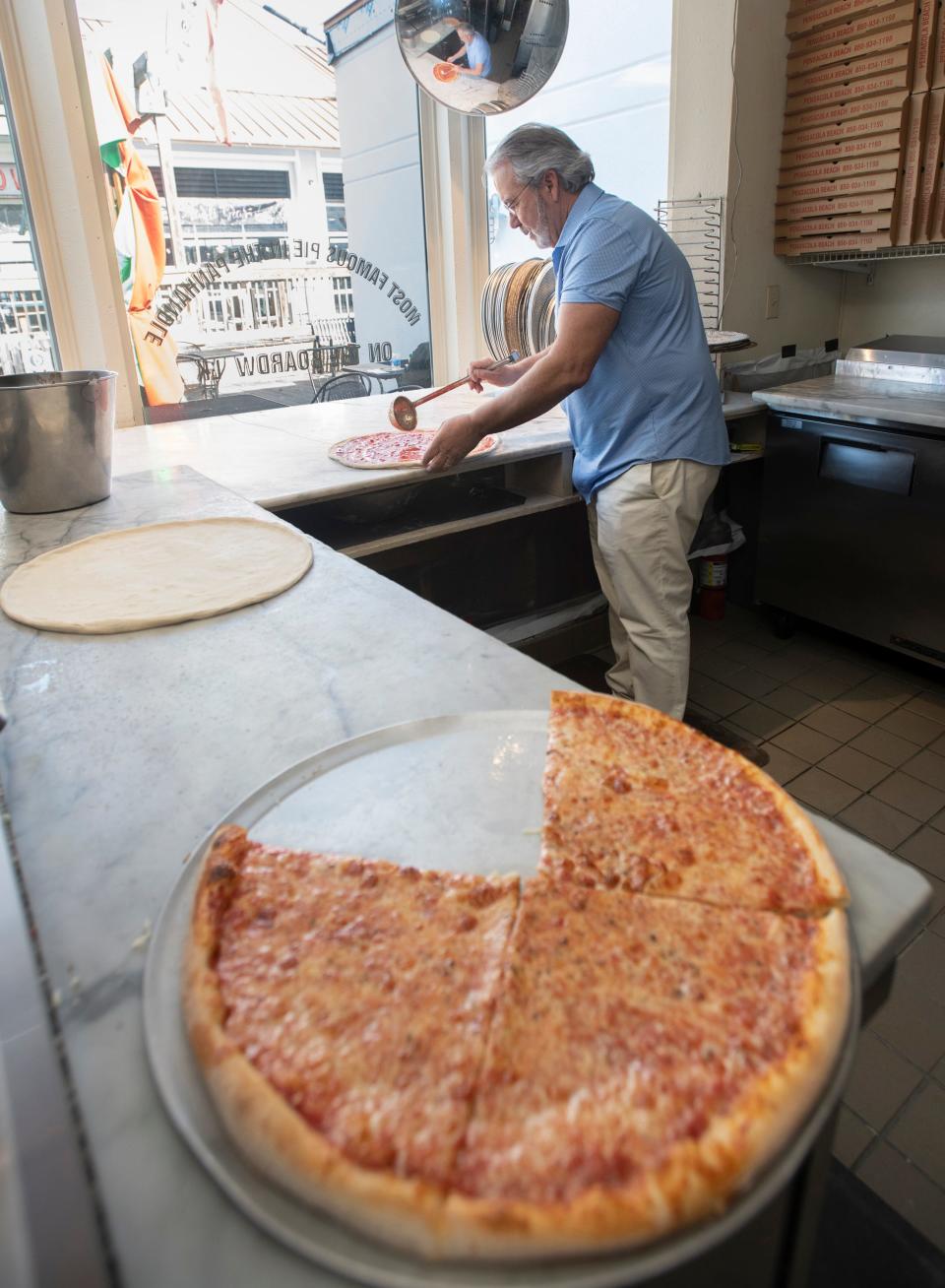 Owner Mike Pinzone makes a pizza at Papa's Pizza on the Pensacola Beach Boardwalk on Monday.