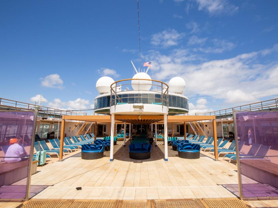 Lounge chairs on the deck of a cruise ship with a walking platform.