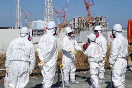 Journalists in protective clothing visit the stricken Fukushima nuclear power plant this week. No individual can be held responsible for the nuclear meltdowns at Fukushima, Japan's prime minister said Saturday, insisting everyone had to "share the pain"