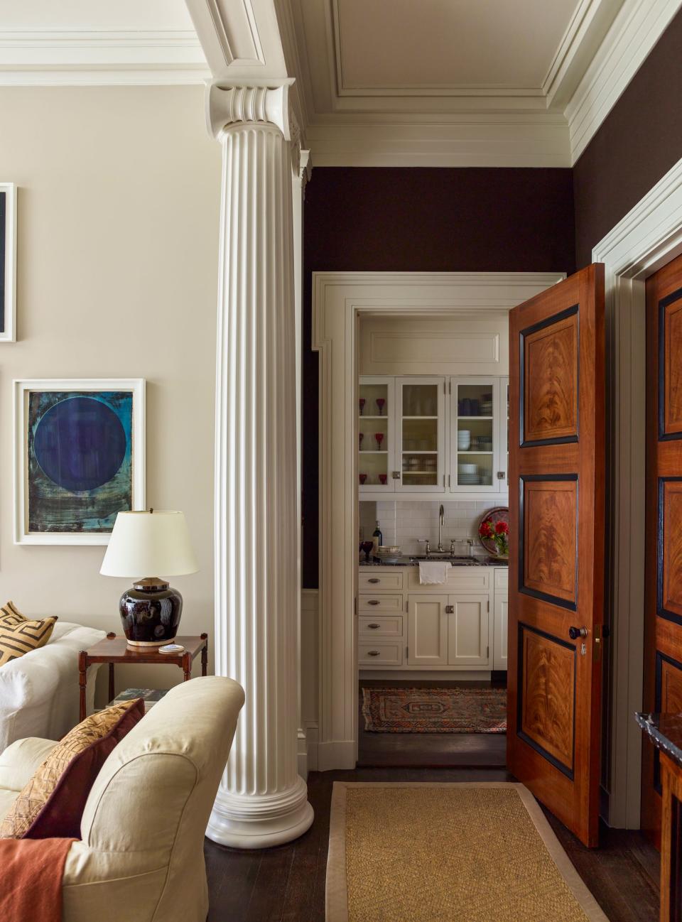 New York artist Jean Carrau created the faux wood–grained mahogany doors throughout the apartment; the hardware is from E.R. Butler & Co. Walls are upholstered in brown felt fabric from Rogers & Goffigon.