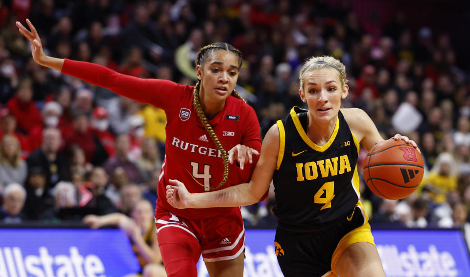 Iowa guard Kylie Feuerbach, right, drives to the basket against Rutgers guard Antonia Bates during the first half of an NCAA college basketball game Friday, Jan. 5, 2024, in Piscataway, N.J. (AP Photo/Noah K. Murray)