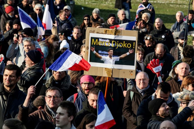 Un manifestant brandit une pancarte sur laquelle est inscrit "Merci Djoko" lors d'une mobilisation contre le pass vaccinal sur la place du Trocadéro, à Paris, le 15 janvier 2022 (AFP/GEOFFROY VAN DER HASSELT)