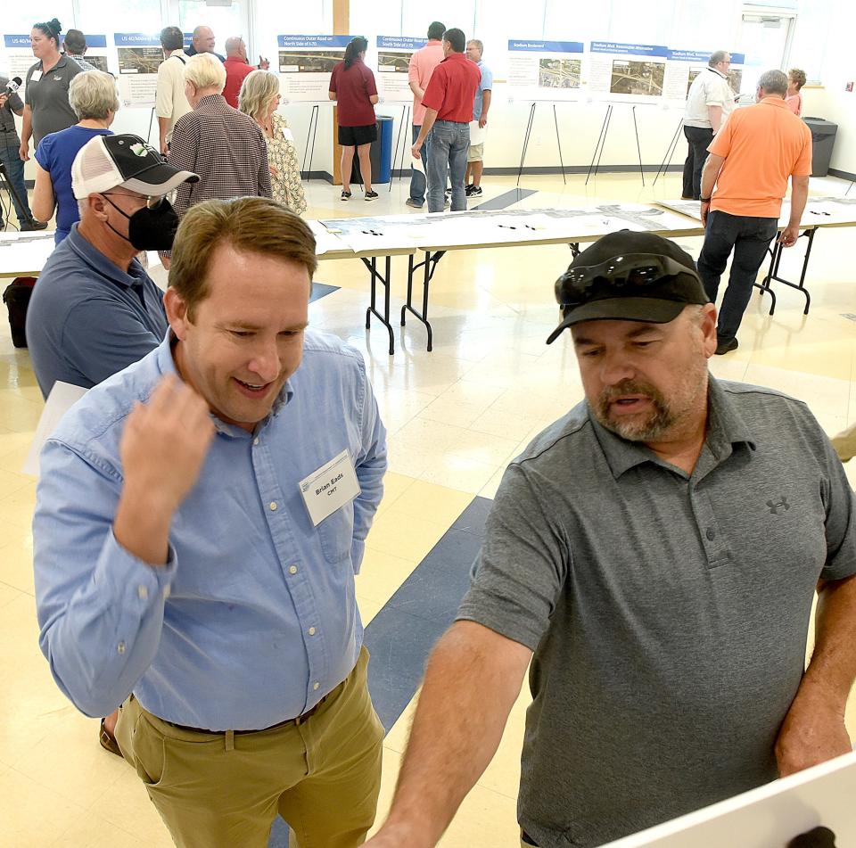 Brian Eads, left, from Crawford, Murphy and Tilly Inc., an engineering and consulting firm in St. Louis, talks to Alan Niederschulte on Thursday at the MODOT open house to explain the environmental study and preparation for changes at the 70/63 interchange.