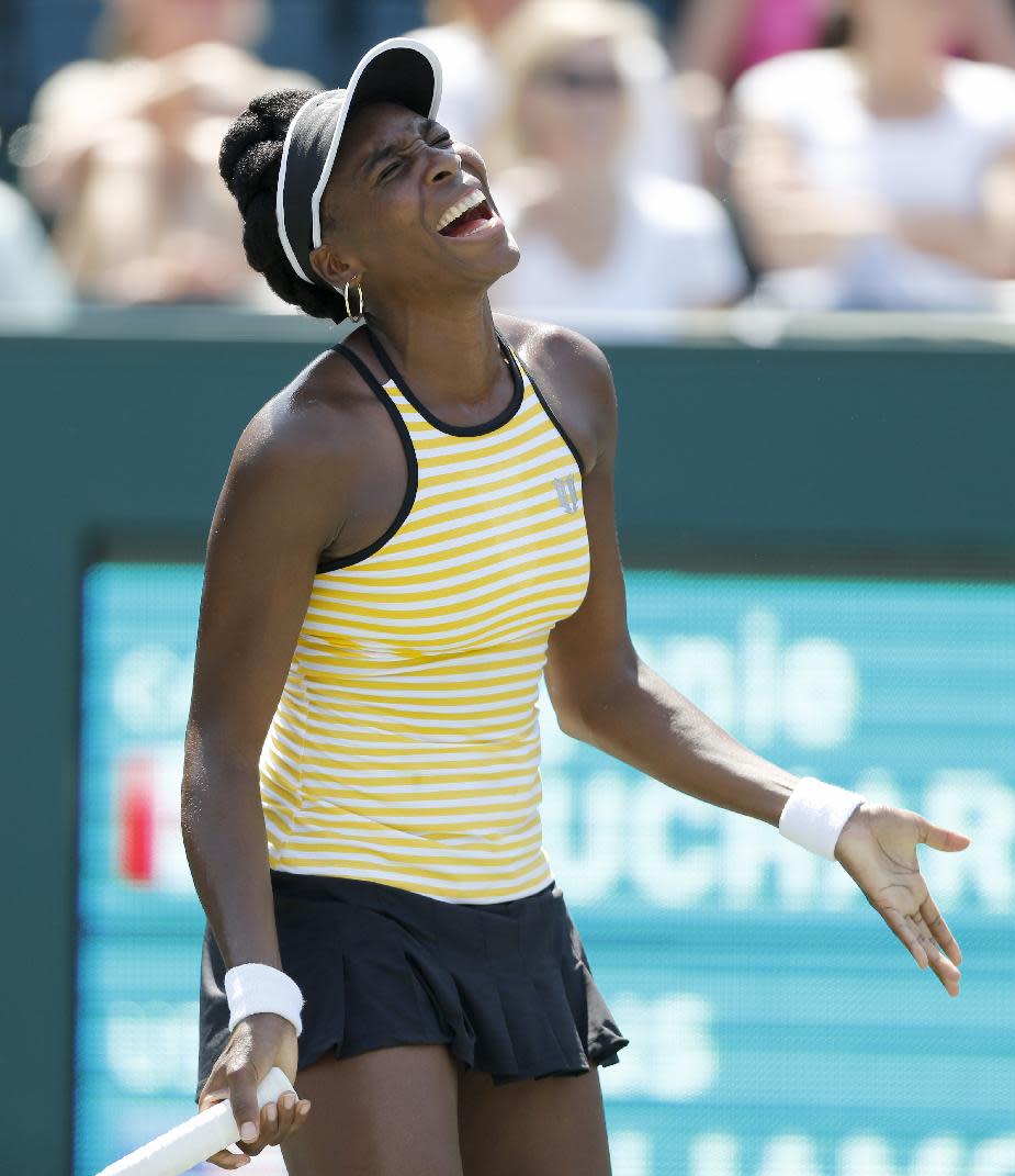 Venus Williams reacts during her match against Eugenie Bouchard, of Canada, during the Family Circle Cup tennis tournament in Charleston, S.C., Thursday, April 3, 2014. (AP Photo/Mic Smith)