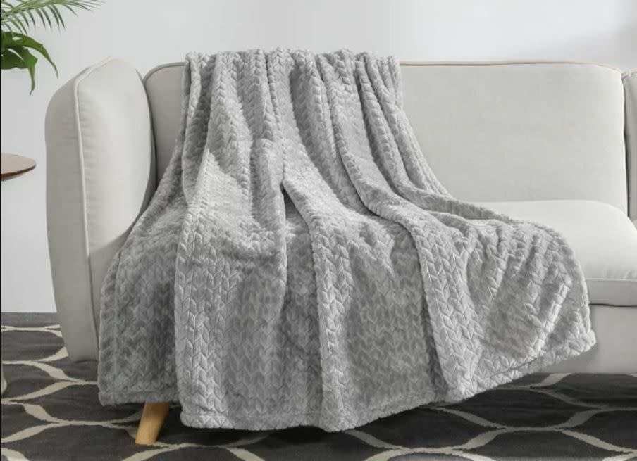 grey plush throw blanket sitting on couch