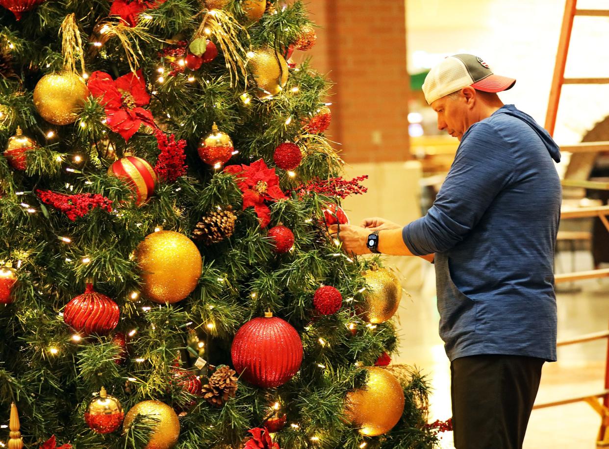 Jordan Creek Town Center General Manager Randy Tennison helps assemble a tree for the mall's 2023 holiday season.