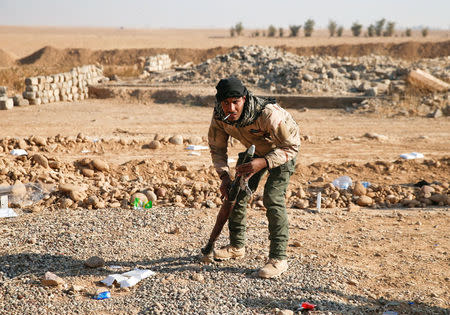 A member of the Iraqi Army stands during clashes with Islamic State militants at the south of Mosul, Iraq December 12, 2016. December 12, 2016. REUTERS/Ammar Awad