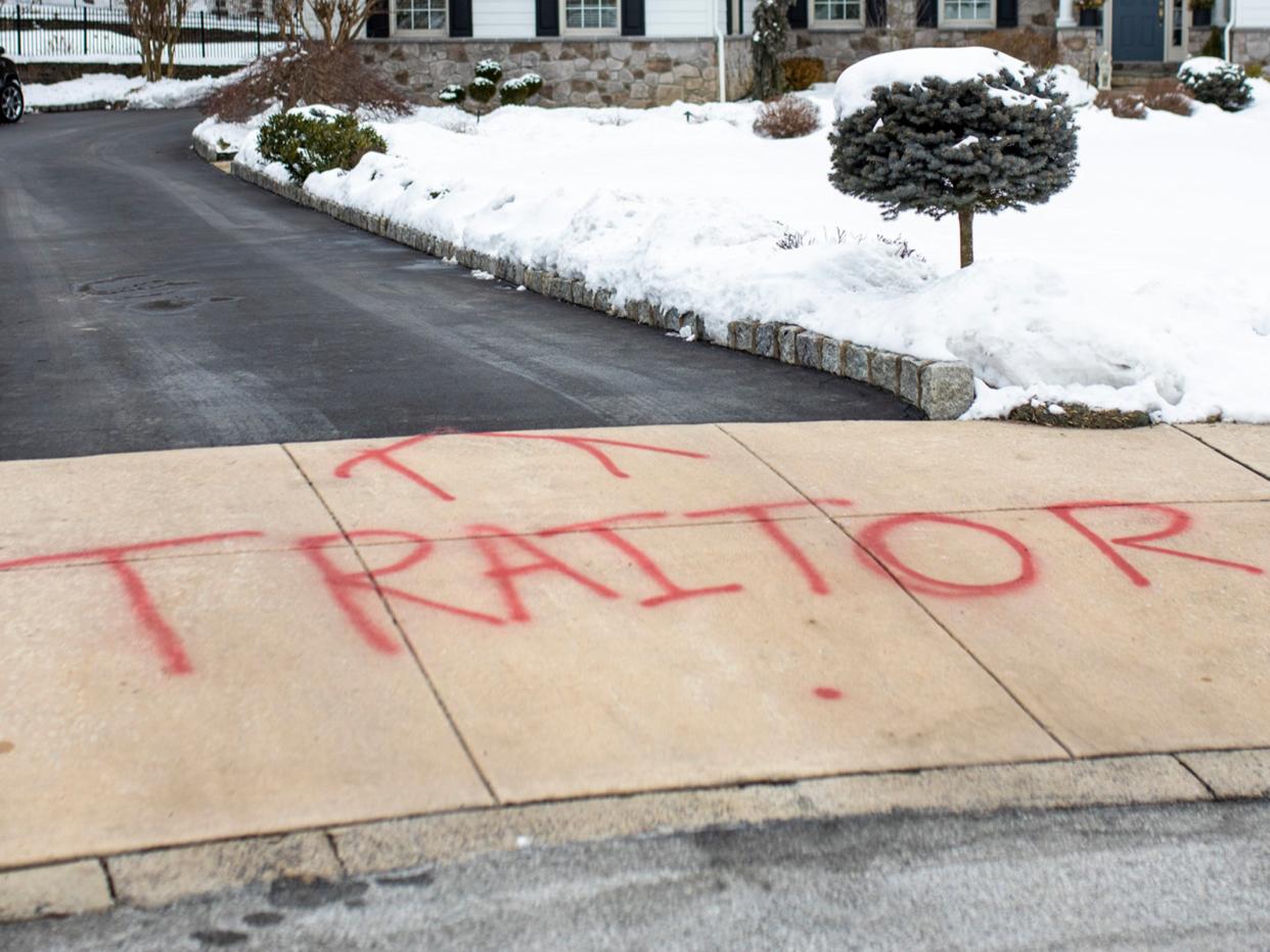 <p>Graffiti is spray painted on the driveway outside of attorney Michael van der Veen’s suburban Philadelphia home, Saturday on 13 February 2021</p> ((Associated Press))