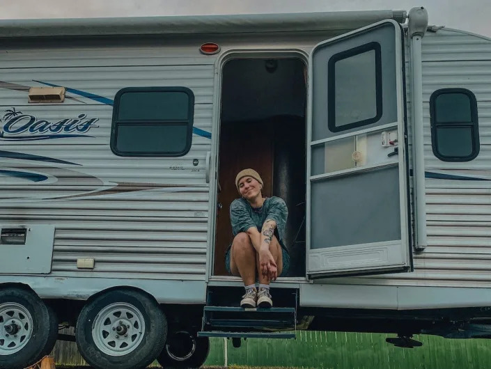 Heather Mclarry sits in the entrance of her 2015 camper.