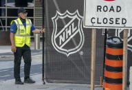 A security guard opens a gate for an empty player bus as it departs the Scotiabank Arena in Toronto, Thursday, Aug. 27, 2020. The NHL has postponed the next two days of playoff games. There has been criticism from Black players who said the league was slow to acknowledge the police shooting of Jacob Blake in Wisconsin. (Frank Gunn/The Canadian Press via AP)