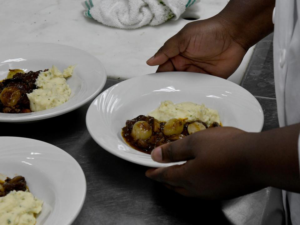 Naphtalie Charlotin plates food for a presentation Wednesday, Nov. 30, 2022, at the Wor-Wic Community College in Salisbury, Maryland. 