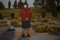 A woman attends a funeral of a Jewish man who died from coronavirus in the costal city of Ashkelon, Israel, Thursday, April 2, 2020. (AP Photo/Tsafrir Abayov)