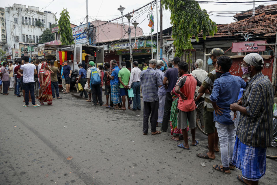 People line up to receive free meal distributed by a voluntary organization during relaxation hours of a lockdown put in place to curb the spread of coronavirus pandemic in Kolkata, India, Wednesday, June 16, 2021. (AP Photo/Bikas Das)