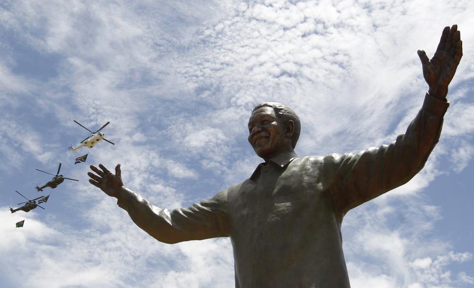 Helicopters fly past a 9-metre bronze statue of the Nelson Mandela after it was unveiled as part of the Day of Reconciliation Celebrations at the Union Buildings in Pretoria