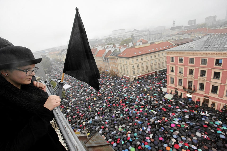 A woman observes thousands of people marching for abortion rights&nbsp;in Warsaw's Old Town.