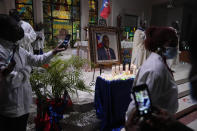 Mourners take pictures of electric candles resting in front of a portrait of Haiti's assassinated President Jovenel Moïse, during a memorial service at Notre Dame d'Haiti Catholic Church on Thursday, July 22, 2021, in the Little Haiti neighborhood of Miami. Miami's Haitian Consul General hosted the service for members of the city's large Haitian community to pray for the troubled nation and pay their respects to the president, who was slain in a July 7 attack at his home which left his wife seriously wounded. (AP Photo/Rebecca Blackwell)