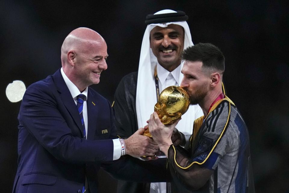 FIFA president Gianni Infantino, left, presents the World Cup trophy to Lionel Messi.